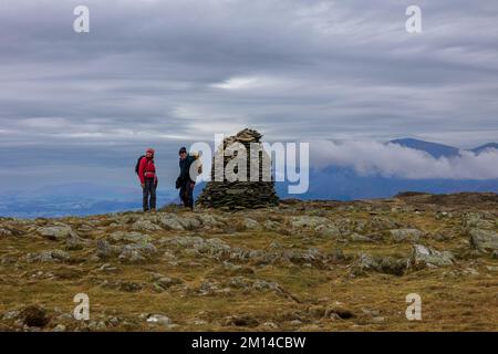 Due escursionisti alla cima del Cairn di High Spy, un Wainwright, nel Distretto Inglese del Lago Foto Stock