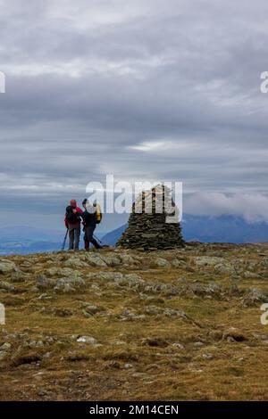 Due escursionisti alla cima del Cairn di High Spy, un Wainwright, nel Distretto Inglese del Lago Foto Stock