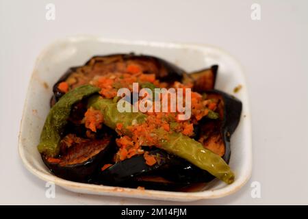 Melanzana fritta e peperoni verdi sott'aceto, aglio, peperoncino rosso, aceto, limone, coriandolo, prezzemolo, pomodori e spezie a pezzi, Foto Stock