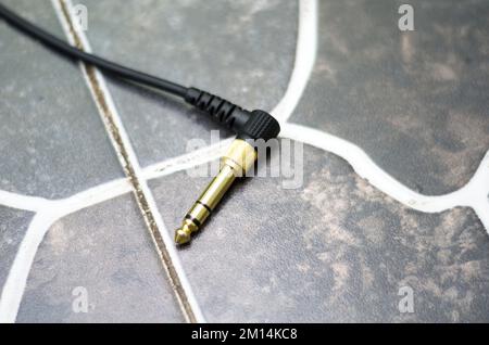 Immagine ravvicinata del cavo jack audio 3,5mm con convertitore 6,35mm collegato Foto Stock