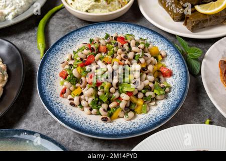 Tradizionale turco e greco tavolo da pranzo antipasto. Antipasto mediterraneo. Insalata di cowpea secca, insalata di melanzane arrosto, olive farcite, roba Foto Stock