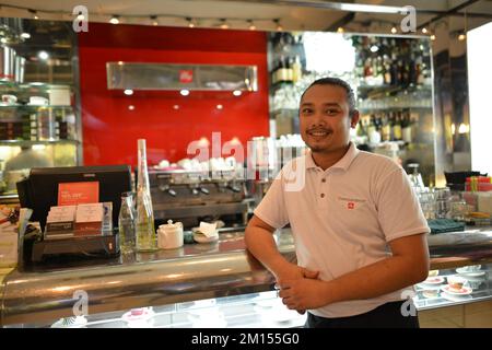 KUALA LUMPUR-APRILE 26: Cameriere in Espersamente Illy cafe il 26 Aprile 2014 a Kuala Lumpur, Malesia. Illycaffe è un'azienda italiana di torrefazione del caffè Foto Stock