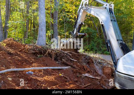 Lo sradicamento di alberi e la preparazione di terreni per la costruzione richiedono l'uso del trattore Foto Stock