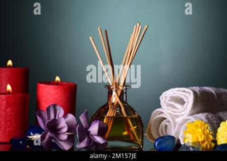 Diffusore aromatico a canna con candela e fiori Foto Stock