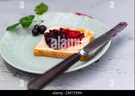 Pane tostato con marmellata di ribes nero Foto Stock