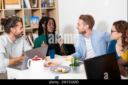 Gruppo di studenti multirazziali che studiano insieme per un esame universitario. Ritratto di giovani uomini d'affari in abbigliamento casual elegante Foto Stock