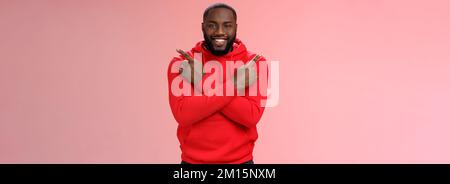 Felice bel ragazzo bearded che punta i lati diversi croce dita sinistra giusto sorridente felicemente chiedendo parere alla ragazza consiglio che scelta fanno Foto Stock