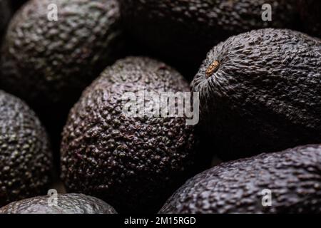 Dall'alto la cornice completa di avocado marrone intero maturo messo insieme come sfondo Foto Stock