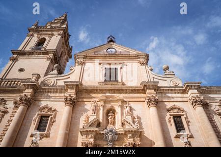Dal basso della storica Cattedrale di San Giovanni Battista situata in Italia sotto il cielo nuvoloso blu Foto Stock