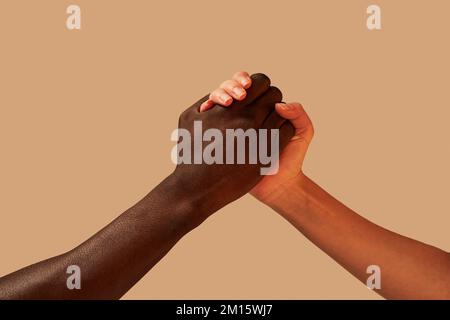 Crop anonimo afroamericano uomo tenendo le mani con la donna in studio vicino sfondo rosa Foto Stock