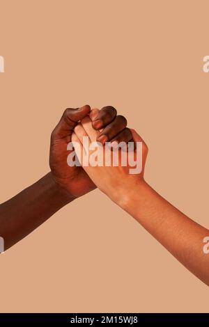 Crop anonimo afroamericano uomo tenendo le mani con la donna in studio vicino sfondo rosa Foto Stock