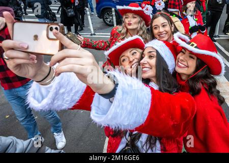 New York, Stati Uniti. 10th Dec, 2022. I festaioli vestiti come Babbo Natale si divertono vicino a Times Square durante l'annuale Santacon a New York City. Credit: Enrique Shore/Alamy Live News Foto Stock