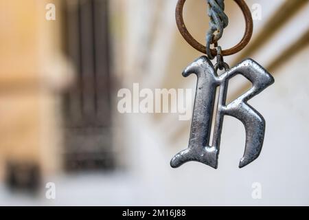 Pendente arrugginito lettera R. su una catena. Foto Stock