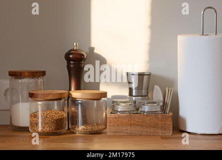 vasetti e contenitori vari su tavolo da cucina e sfondo parete Foto Stock