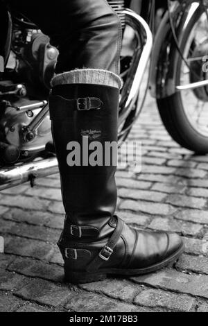 un primo piano di un uomo che indossa un paio di stivali in pelle fatti a mano per motociclette Foto Stock