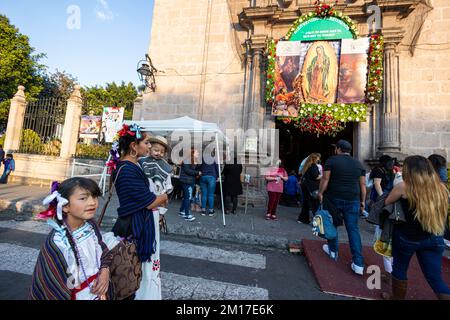 Morelia, Messico, 10 dicembre 2022, Una madre e i suoi figli arrivano al tempio durante le celebrazioni del giorno della Vergine di Guadalupe. Milioni di messicani di tutte le età celebrano questa festa religiosa che culmina il 12th dicembre vestendo come Juan Diego o la Vergine di Guadalupe e andando al tempio dedicato alla vergine in ogni città. Brian Overcast/Alamy Live News. Foto Stock