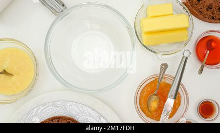 Processo di cottura. Preparazione della crema al burro per la ricetta della torta al cioccolato. Ingredienti per la crema chiudere sul tavolo da cucina, piatto Foto Stock