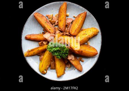 zeppe di patate rustiche con pancetta su sfondo nero vista dall'alto Foto Stock