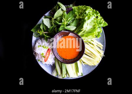 Piatto con foglie vietnamite e spaghetti di riso, salsa piccante per zuppe o panini primaverili, vista dall'alto Foto Stock