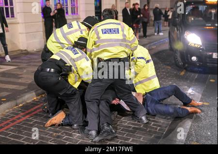 Broad Street, Birmingham, dicembre 10th 2022 - questo è stato il momento drammatico in cui due uomini, che inizialmente sono stati cacciati dal nightclub Reflex, sono stati affrontati a terra da ufficiali dopo che si sono tirati indietro verso i festaioli in coda per entrare. Qualcuno all'interno della mischia si sentiva dire "mi sta mordendo" gli ufficiali della polizia delle West Midlands discesero rapidamente sull'incidente di Broad Street sabato 10 dicembre sera. Uno dei volti dei trasgressori è stato sanguinato ed entrambi sono stati portati a mano in furgoni di polizia in attesa. La notte aveva iniziato la calma a causa della sconfitta del 2-1 contro la Francia. Alcuni partygoers sono stati visti st Foto Stock