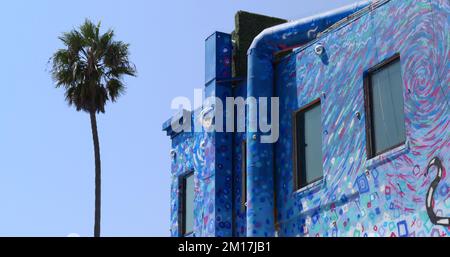 Splendido edificio colorato accanto ad una palma sul lungomare di Venice Beach Foto Stock