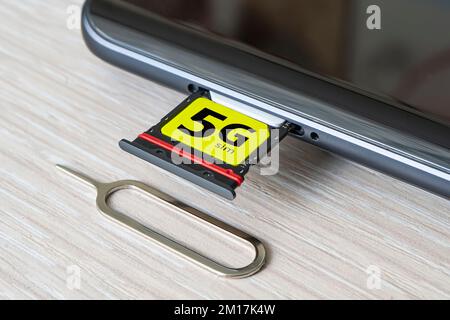 Sostituzione di una scheda SIM 4G con una scheda 5g ad alta velocità Scheda SIM da vicino sul tavolo in legno del negozio Foto Stock