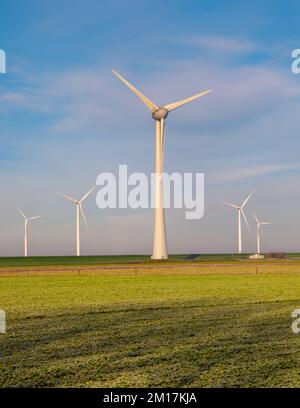 Vista al parco dei mulini a vento con turbine eoliche durante l'inverno che generano elettricità con un concetto di energia verde cielo blu Foto Stock