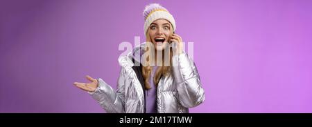 Talkative Amused bionda ragazza sentire impressionante buona notizia alzare mano sorpreso felice parlare smartphone allargare gli occhi soddisfatto perfetto informazioni, in piedi Foto Stock