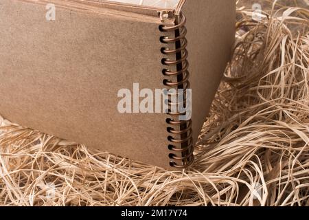 Notebook a spirale posizionato su uno sfondo di paglia Foto Stock