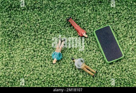 Figurina minuscola dell'uomo e bacheca sulla sabbia Foto Stock