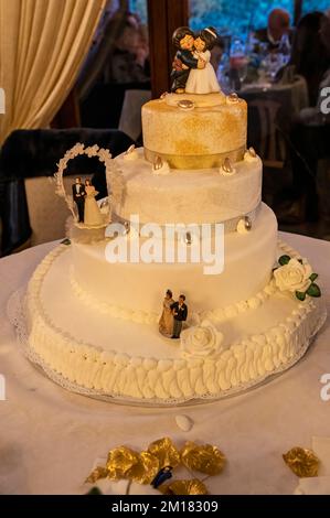 torta nuziale a tre livelli sul tavolo della sposa e sposo con decorazioni Foto Stock