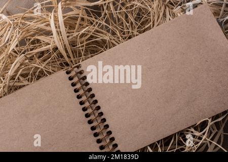 Notebook a spirale posizionato su uno sfondo di paglia Foto Stock