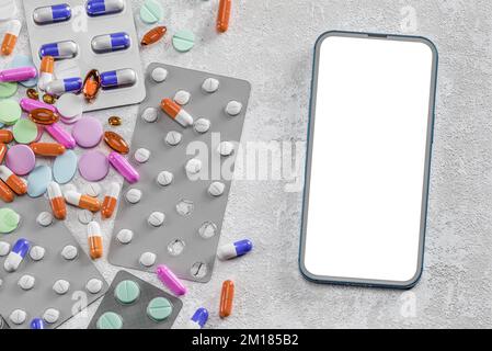 consultazione medico farmacista online. il mockup del telefono delle cellule sullo sfondo di droghe, pillole, medicine e supplementi. App farmacista online. stato app m Foto Stock