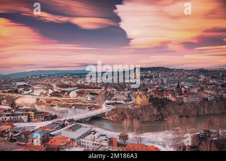 Tbilisi, Georgia. Fantastiche nuvole da sogno Trails in Sky. Skyline della capitale georgiana. Città fantasy durante le illuminazioni al tramonto e notturne. Insolito Foto Stock