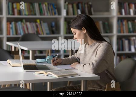 Messa a fuoco bella studentessa studentessa in biblioteca pubblica Foto Stock