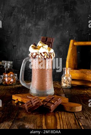 Cioccolato al ghiaccio con bevanda marshmallow tostata su sfondo scuro. Foto Stock