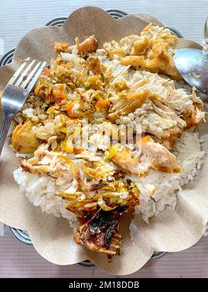 Pollo indonesiano piccante Geprek con riso (Nasi Ayam Geprek) mescolato, piatto unico originariamente da Yogyakarta, Indonesia. Foto Stock