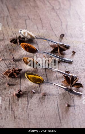 Spezie tipiche brasiliane - mandorle, cannella, paprika e curcuma in polvere in un cucchiaio su un tavolo di legno rustico. Foto Stock