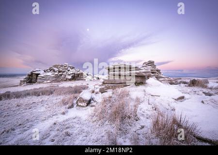 Merrivale, Dartmoor National Park, Devon, Regno Unito. 11th Dec, 2022. UK Weather: Fuoco e ghiaccio su Dartmoor. La tenda solita di un coraggioso "camper selvaggio" che ha allestito un accampamento alla base di un Grande Mis Tor innevato. Le condizioni invernali sono previste per continuare questa settimana con ulteriori previsioni sulla neve. Credit: Celia McMahon/Alamy Live News Foto Stock