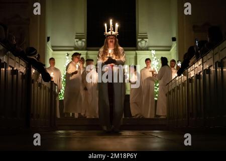 Londra, Regno Unito. 10th dicembre 2022. Festa di Sankta Lucia nella Chiesa del Bosco di San Giovanni. Clara Nordin del Coro nordico londinese indossa una corona di candele che simboleggiano Santa Lucia mentre conduce la celebrazione di Sankta Lucia, basata sul coraggio e sul martirio di una giovane ragazza siciliana Santa Lucia (Lucia di Siracusa 283-304). Credit: Guy Corbishley/Alamy Live News Foto Stock