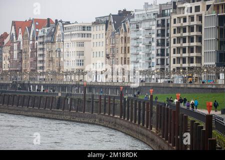 11 dicembre 2022, Renania settentrionale-Vestfalia, Düsseödorf: Passeggini camminano lungo la passeggiata lungo il Reno di Düsseldorf in condizioni di clima cupo al terzo Avvento. Foto: Thomas Banneyer/dpa Foto Stock