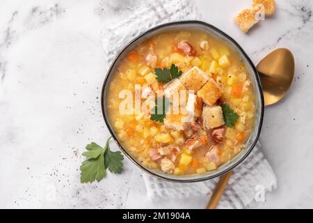 Zuppa di piselli di lenticchie guarnire con prosciutto e costolette di maiale Foto Stock