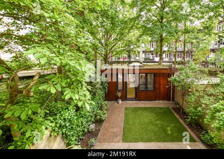 un giardino con alberi e piante in primo piano - immagine gentilmente concessa dalla pagina facebook dell'agente immobiliare / immobiliare Foto Stock