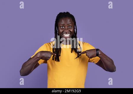 Sorpreso uomo nero dai capelli lunghi che indica se stesso Foto Stock