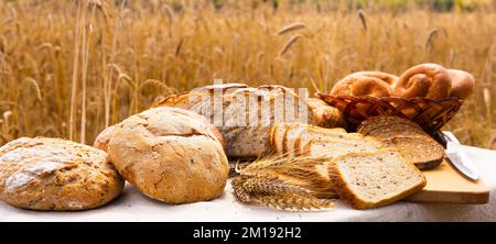 lotto di pane, grano, segale aromatizzato, sulla tavola all'esterno del campo Foto Stock