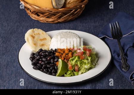 Casado, piatto tipico della Costa Rica con riso, fagioli e verdure in piatto bianco. Foto Stock