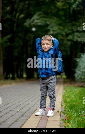 Ritratto di un primo grader con uno zaino. Il ragazzo va a scuola. Foto Stock