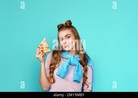 donna con fetta di pizza su sfondo blu. Foto Stock