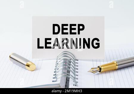 Concetto finanziario e commerciale. Sul tavolo c'è un taccuino, una penna e un biglietto da visita con l'iscrizione - APPRENDIMENTO PROFONDO Foto Stock