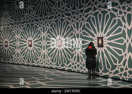 Londra, Regno Unito. 11th Dec, 2022. I visitatori guardano le opere esposte. Lo spazio Curve del Barbican è stato trasformato in una galleria immersiva con pavimenti e soffitti dipinti a mano in motivi islamici per la mostra Soheila Sokhanvari 'Rebel Rebell'. L'artista iraniano raffigura figure culturali iraniane in colorati ritratti in miniatura, mostrando la contraddizione tra la vita delle donne iraniane tra la rivoluzione del 1920s e del 1979. La mostra è gratuita e fino al 26 febbraio 2023. Credit: Imageplotter/Alamy Live News Foto Stock